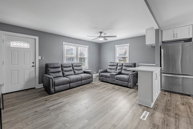 living room with plenty of natural light, ceiling fan, and light hardwood / wood-style floors