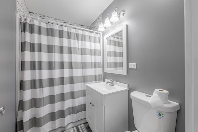 bathroom with vanity, a shower with shower curtain, and toilet