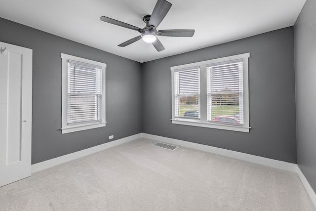 unfurnished room featuring light carpet, ceiling fan, and a healthy amount of sunlight