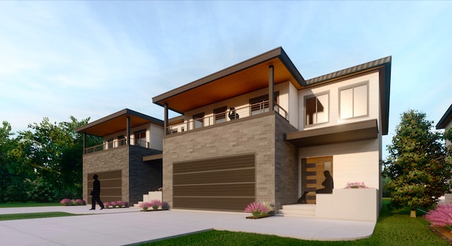 contemporary house featuring a garage and a balcony