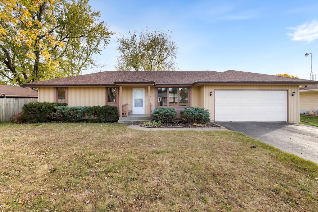 single story home featuring a garage and a front yard