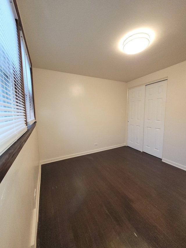 unfurnished bedroom featuring dark hardwood / wood-style floors and a closet