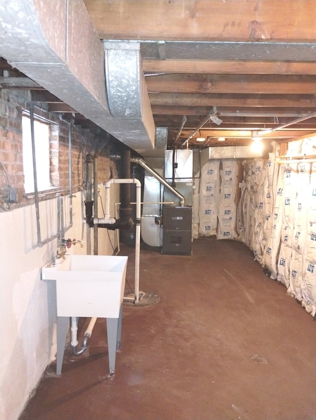 basement with heating unit and sink