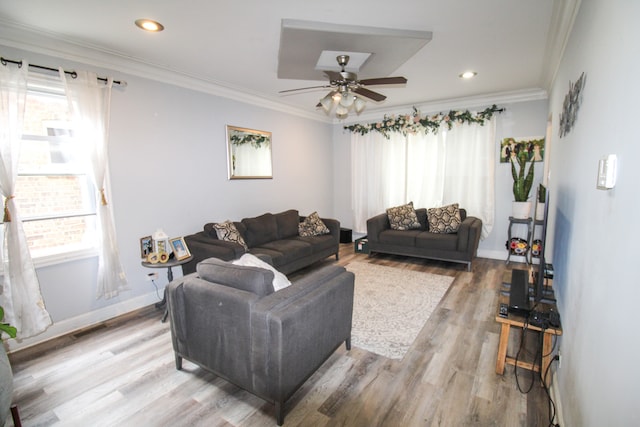 living room with ceiling fan, ornamental molding, and light hardwood / wood-style flooring