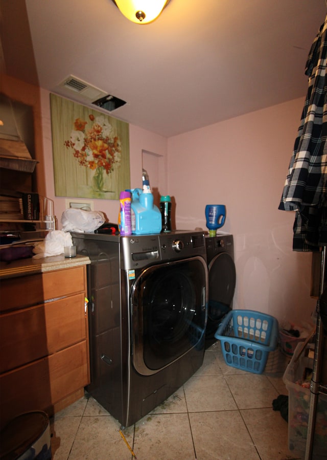 laundry area featuring washer and clothes dryer and light tile patterned floors