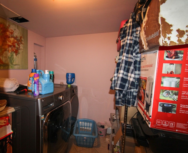 clothes washing area featuring tile patterned floors and washing machine and clothes dryer