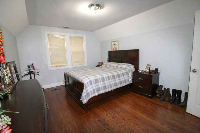 bedroom featuring dark hardwood / wood-style flooring and lofted ceiling