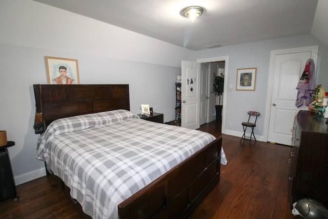 bedroom with dark hardwood / wood-style flooring and lofted ceiling