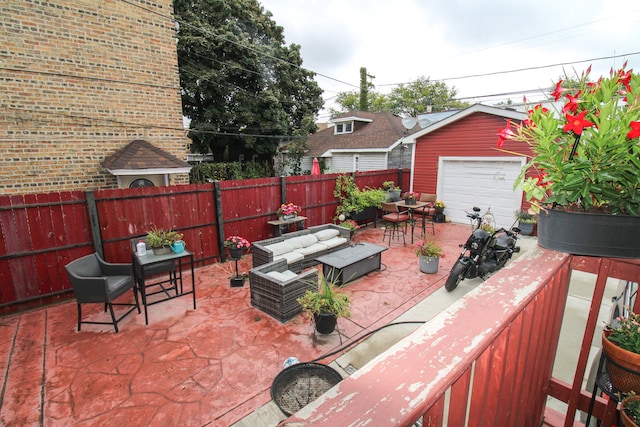 view of patio / terrace featuring a garage, an outbuilding, and an outdoor hangout area