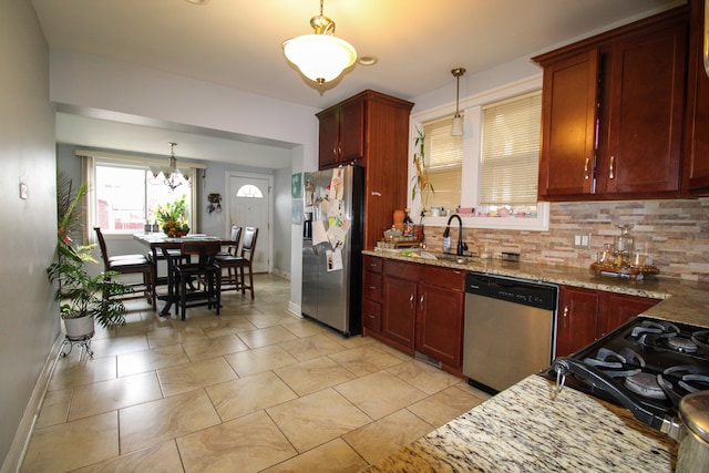 kitchen with backsplash, decorative light fixtures, light stone countertops, and stainless steel appliances