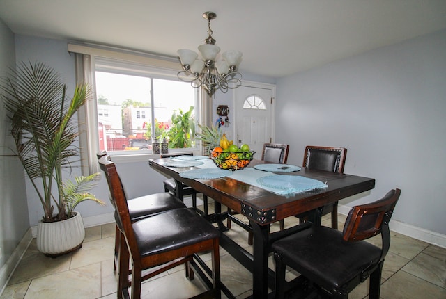 tiled dining room with an inviting chandelier