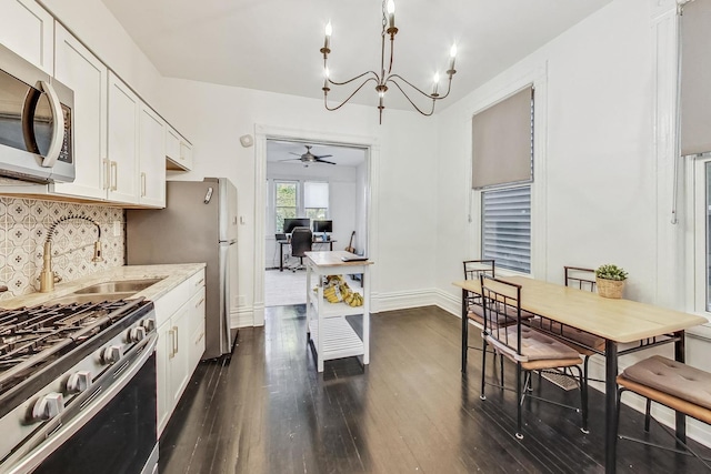 kitchen featuring sink, appliances with stainless steel finishes, light stone countertops, white cabinets, and dark hardwood / wood-style flooring