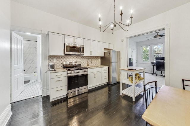 kitchen with stainless steel appliances, white cabinets, and dark wood-type flooring