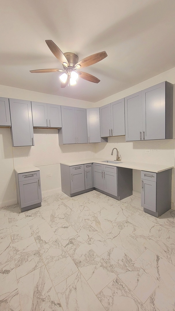 kitchen with gray cabinets, ceiling fan, and sink