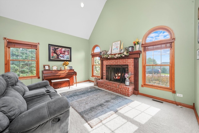 carpeted living room featuring a brick fireplace and high vaulted ceiling