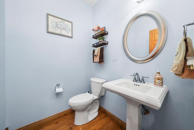 bathroom with toilet and wood-type flooring