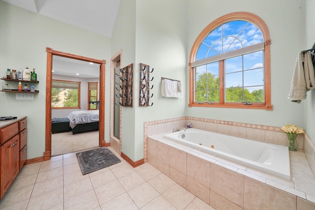 bathroom featuring tile patterned flooring, vanity, lofted ceiling, and independent shower and bath