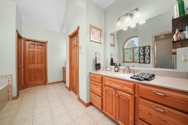 bathroom with tile patterned flooring, vanity, and tiled tub