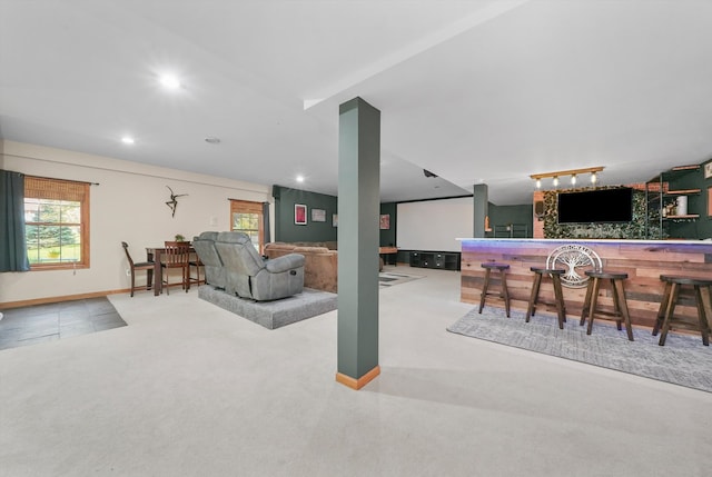 carpeted living room featuring bar area