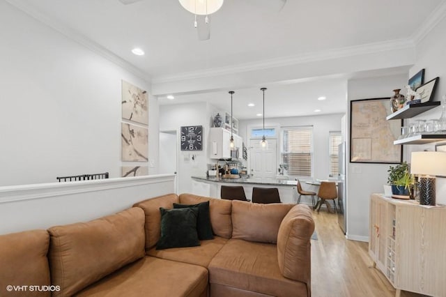 living room with crown molding, light hardwood / wood-style flooring, and ceiling fan