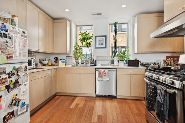 kitchen featuring light hardwood / wood-style flooring, sink, light brown cabinets, appliances with stainless steel finishes, and range hood