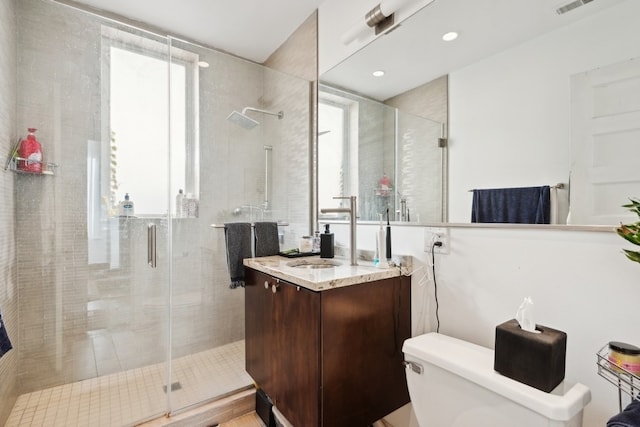 bathroom featuring vanity, toilet, and an enclosed shower