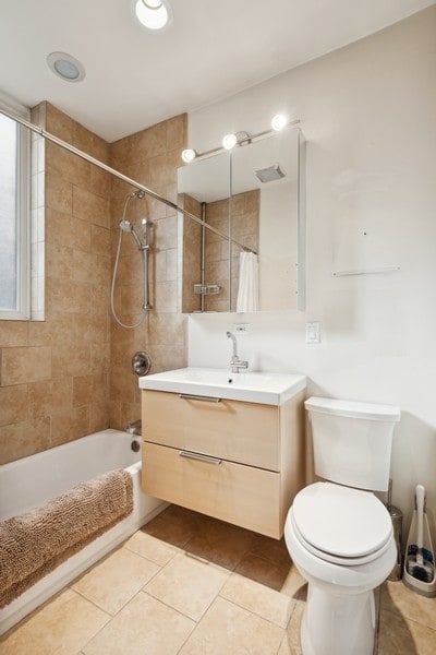 full bathroom with vanity, tile patterned floors, tiled shower / bath, and toilet