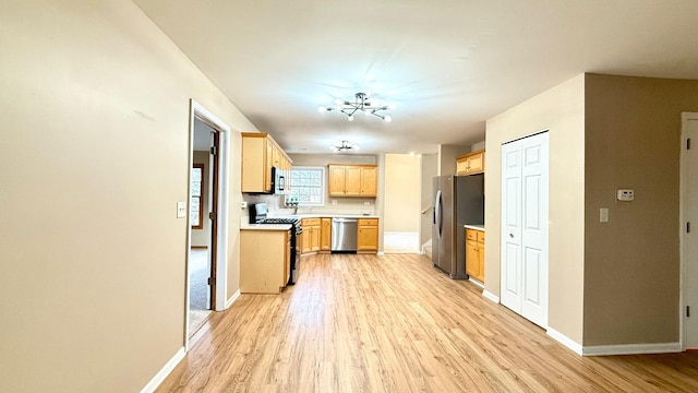 kitchen featuring a chandelier, light hardwood / wood-style flooring, and stainless steel appliances