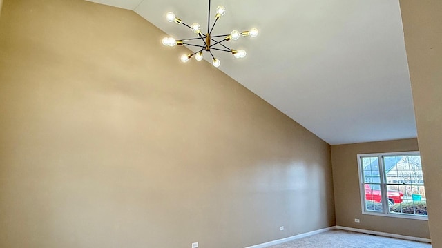 spare room featuring light carpet, a chandelier, and lofted ceiling