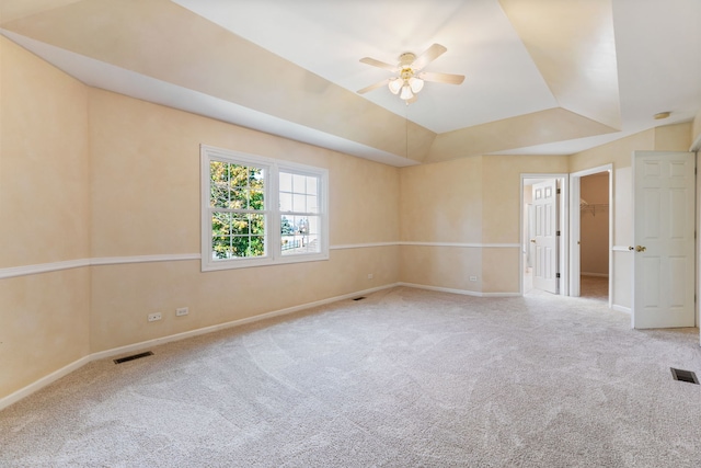 unfurnished room with carpet floors, a raised ceiling, and ceiling fan