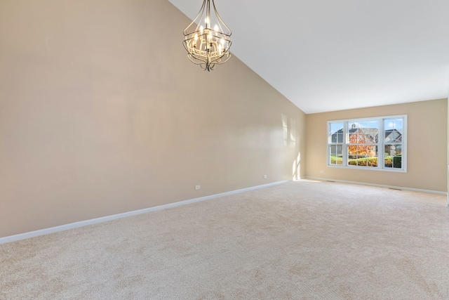 carpeted empty room with high vaulted ceiling and an inviting chandelier