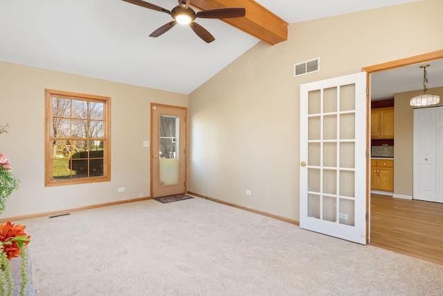 carpeted spare room with vaulted ceiling with beams and ceiling fan