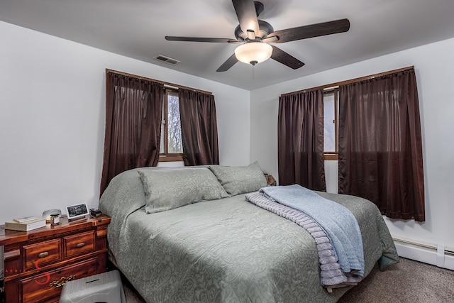 carpeted bedroom with a baseboard heating unit and ceiling fan