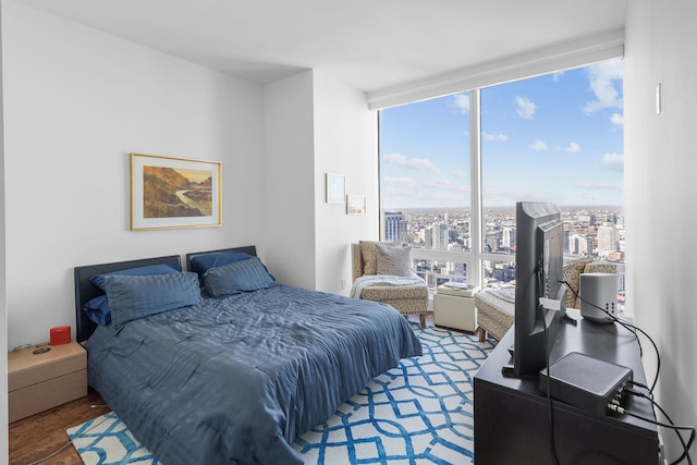 bedroom with expansive windows and wood-type flooring