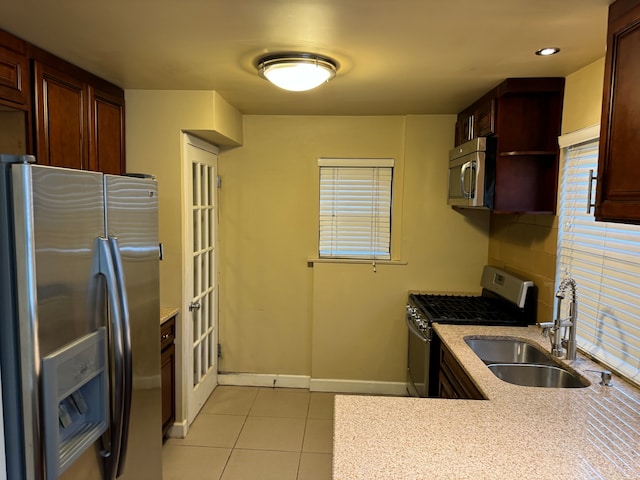 kitchen with stainless steel appliances, light tile patterned floors, and sink