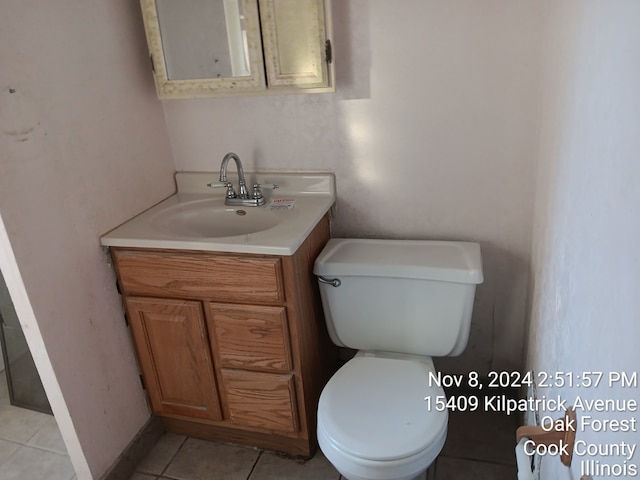 bathroom with tile patterned flooring, vanity, and toilet