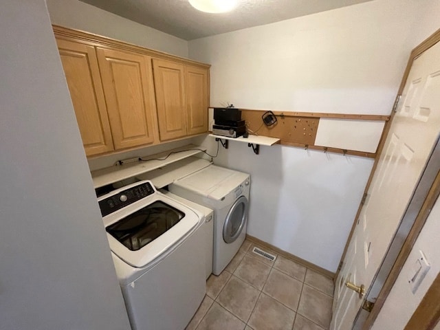 washroom with cabinets, light tile patterned floors, and washer and dryer