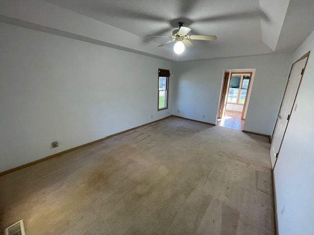 carpeted spare room with ceiling fan and a healthy amount of sunlight