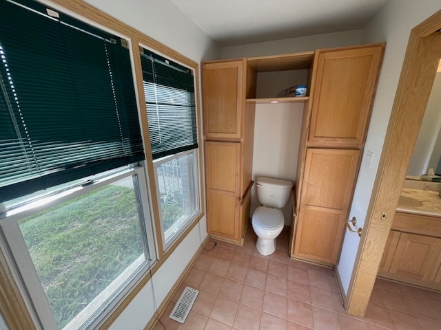 bathroom with tile patterned flooring, vanity, and toilet