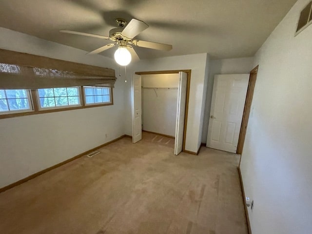 unfurnished bedroom featuring light carpet and ceiling fan