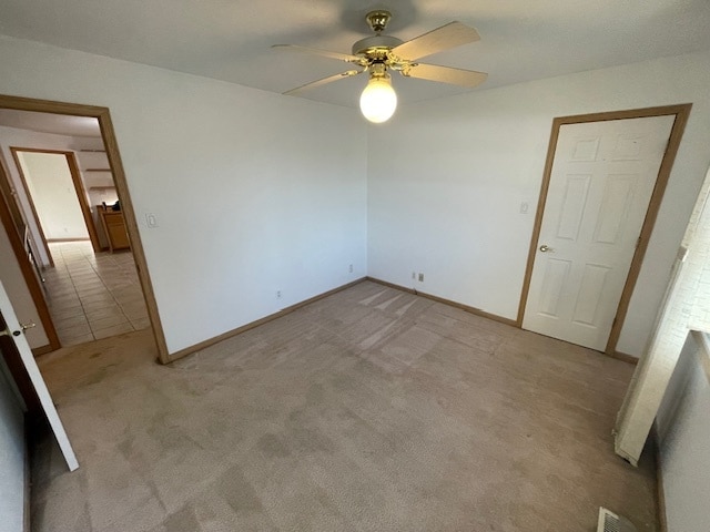 unfurnished bedroom featuring light colored carpet and ceiling fan