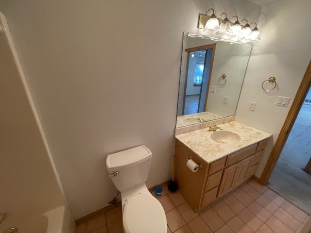 bathroom with tile patterned flooring, vanity, toilet, and a tub