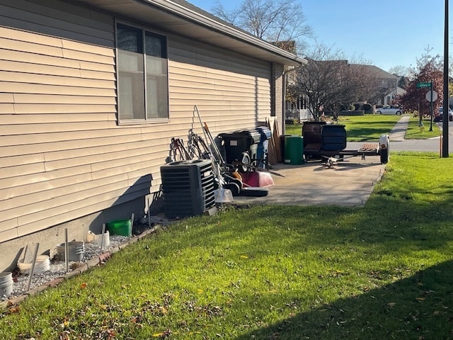 view of side of home with a yard and central AC unit