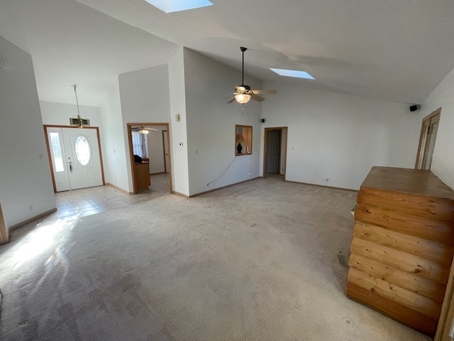 unfurnished living room featuring a skylight, ceiling fan, high vaulted ceiling, and light carpet