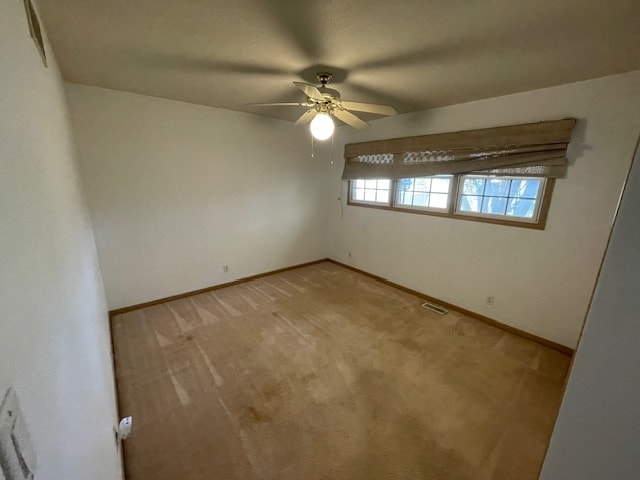 spare room with ceiling fan and light carpet