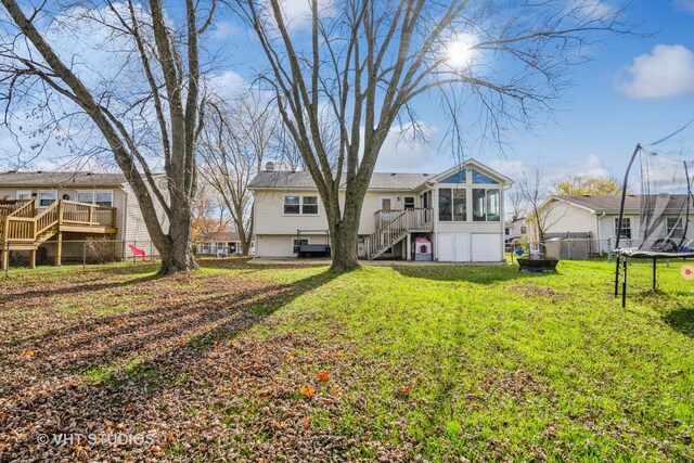 980 Brush Hill Ln, Lake Zurich, IL 60047 - rear view of house featuring a trampoline, stairway, a chimney, a sunroom, and a wooden deck