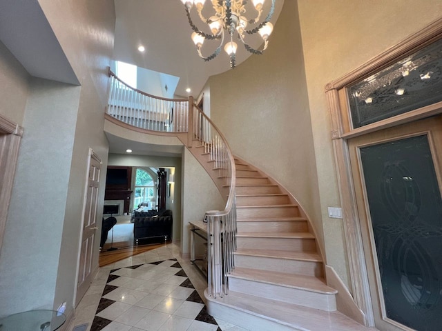 stairs featuring hardwood / wood-style floors, a notable chandelier, and a towering ceiling