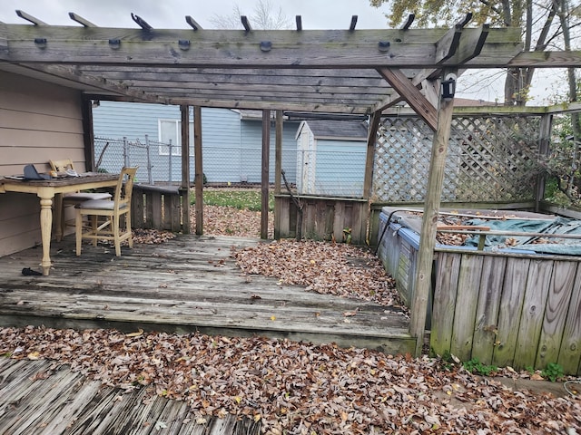 wooden terrace featuring a storage unit and a pergola