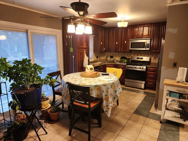 kitchen with ceiling fan, decorative backsplash, light tile patterned flooring, and stainless steel appliances