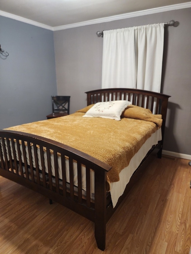 bedroom with hardwood / wood-style floors and crown molding